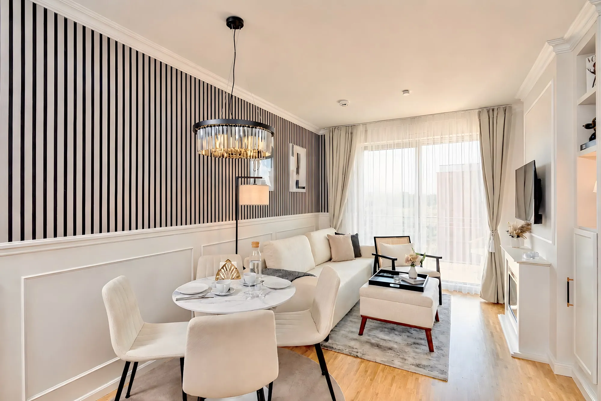 Heller Wohnbereich mit Streifenwand und Kronleuchter im Boutique-Apartment Art Déco in Dresden
